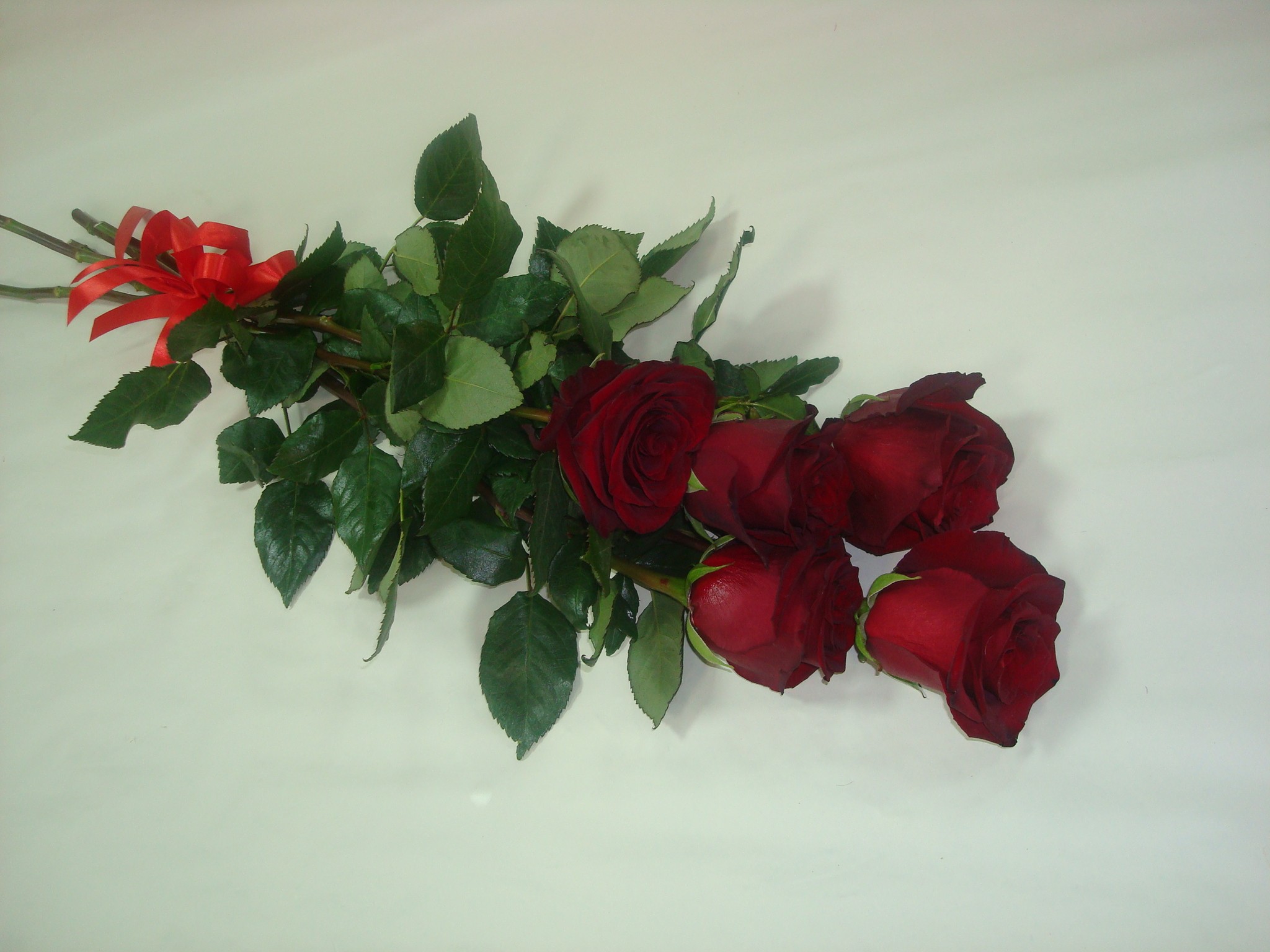 Розы пять штук. Букет из пяти роз. Пять красных роз. Розы на столе. Маленький букет из роз.